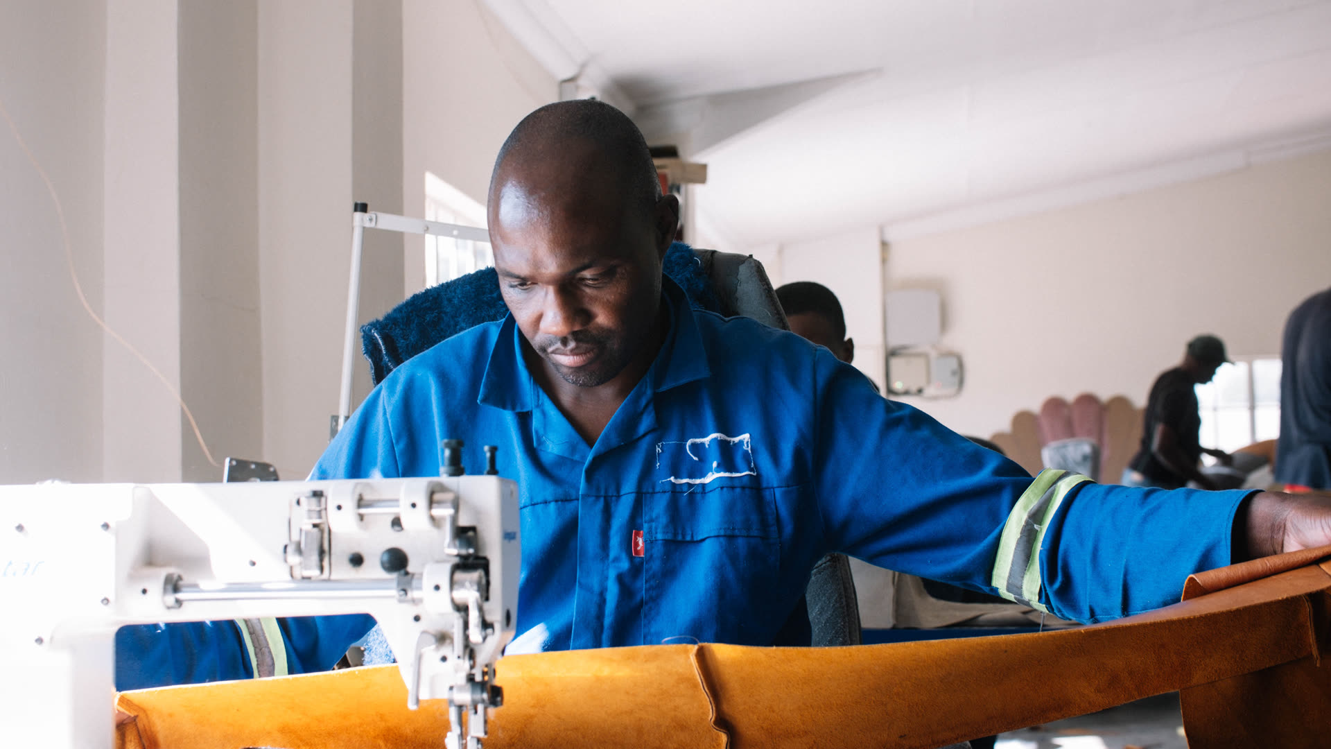 D3 craftsman sewing upholstery in the workshop